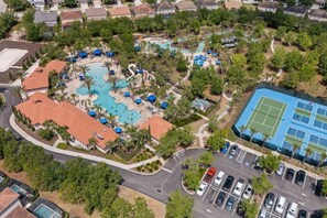 An aerial view of a resort with a swimming pool, tennis courts, and a parking area. - Family Getaway | 6BR, Private Pool & Resort (Davenport)