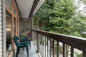 Un balcone con vista su alberi verdi e fitti.