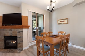 Un comedor con chimenea, televisor y candelabro.