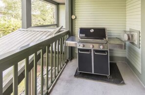Ett takförsett utomhusområde med en grill och en fläkt.