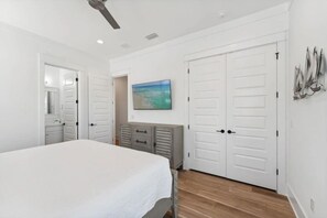 A bedroom with a bed, a dresser, a painting, and a closet. - 7BR Beach Escape | Private Pool + Billiards (Miramar Beach)