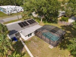 Una propiedad residencial con piscina, un porche cubierto y garaje.