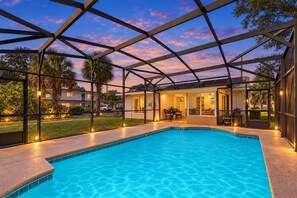 A swimming pool with a covered patio area, surrounded by a metal framework. - Lake Toho Getaway | Pool • Downtown Kissimmee (Kissimmee)
