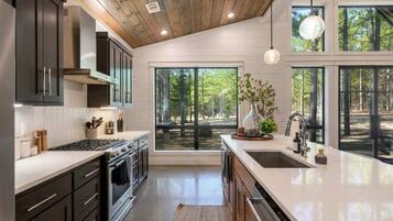 A modern kitchen with a large window, a stove, and a sink.