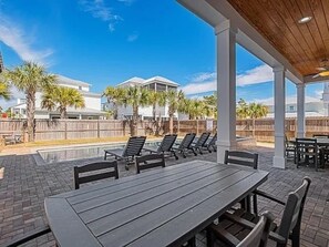 Eine Terrasse im Freien mit Pool, Liegestühlen und einem überdachten Sitzbereich.