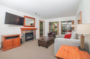 A living room with a fireplace, a television, a sofa, and a coffee table. - 1 Bedroom | Near Whistler Blackcomb Gondola (Squamish-Lillooet)