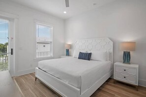 A bedroom with a white bed, two bedside tables, and a window with blinds. - 7BR Destin Paradise | Private Pool • Billiards (Miramar Beach)
