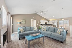 A modern living room with a sectional sofa, a coffee table, and a ceiling fan. - Your Perfect Beach Getaway | Destin Coastal Home (Destin)