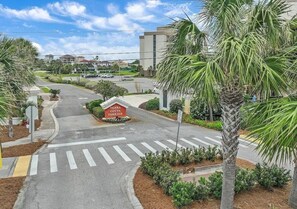 A road intersection with a pedestrian crossing, a sign for 'Terra Cotta Terrace,' and a palm tree. - Destin Family Retreat | Private Pool + Beach (Destin)