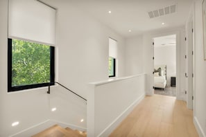 Ein modernes Interieur mit Treppe, Bett und Blick ins Grüne.