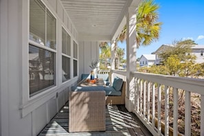 A covered porch with a cushioned seating area, a small table, and a decorative vase. - Santa Rosa Boho Villa | Game | Designs | Beach (Santa Rosa Beach)