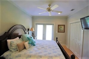 A bedroom with a bed, a ceiling fan, a television, and a door. - 4BR Santa Rosa Beach & Lake Getaway (Santa Rosa Beach)