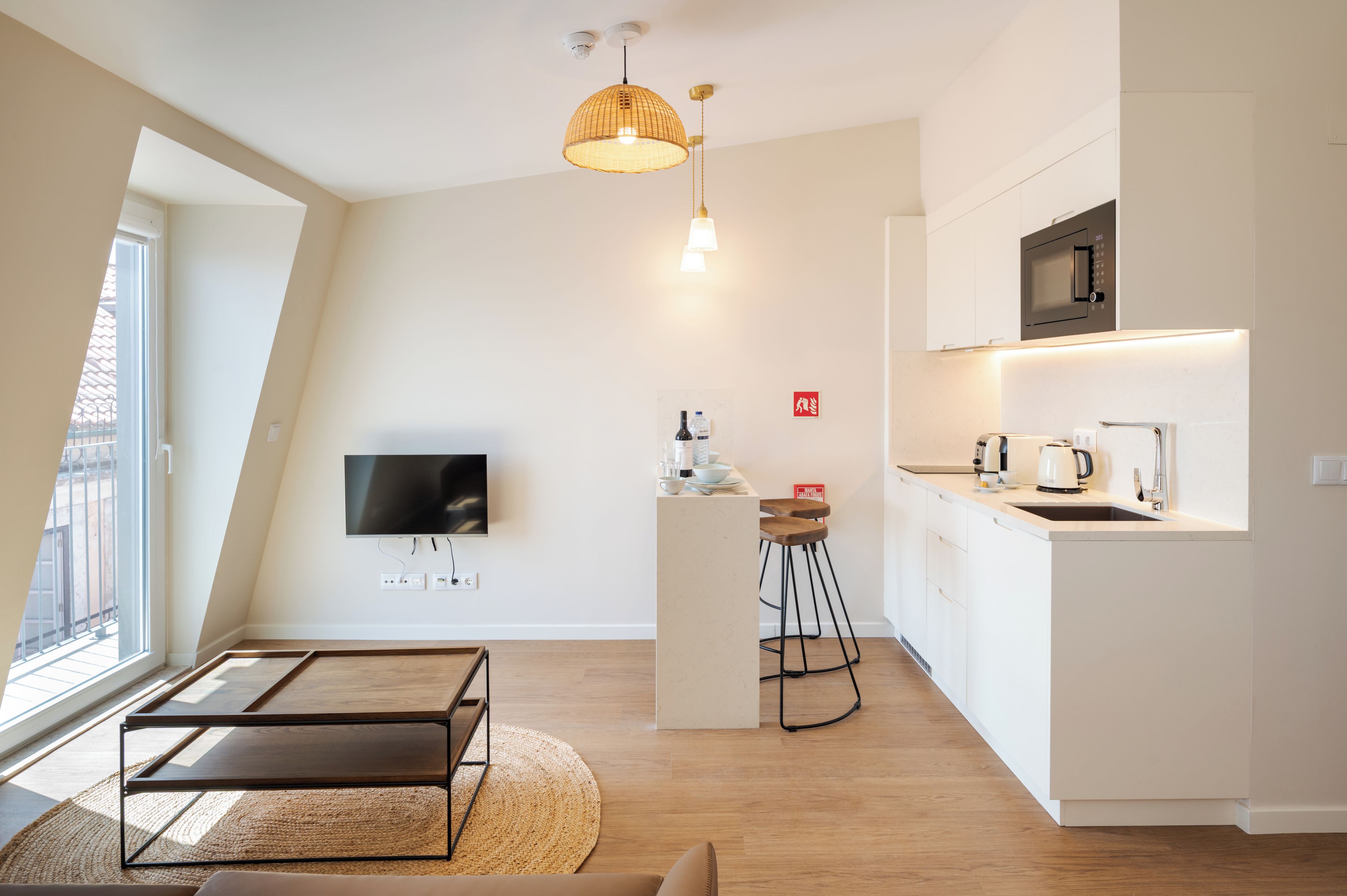 A modern kitchen with a flat-screen TV, a microwave, and a coffee maker.