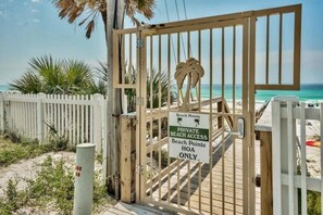 A gated entrance to a private beach with a wooden fence and a sign indicating beach access is for HOA members only. - 3 Story Destin Villa | Private Beach | Shared Pool (Destin)