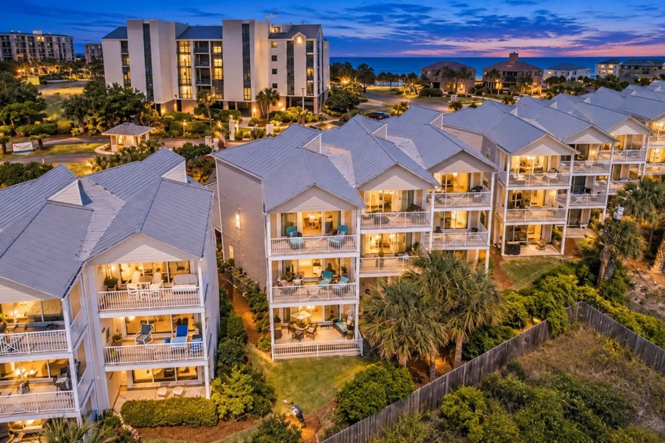 A coastal residential area with multi-story buildings featuring balconies and outdoor seating areas.