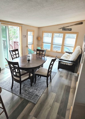 A dining area with a round table, chairs, and a sofa. - Private Home,1+acre property,close to WIDells/CastleRock,FirePit,yard games,wood (Adams)