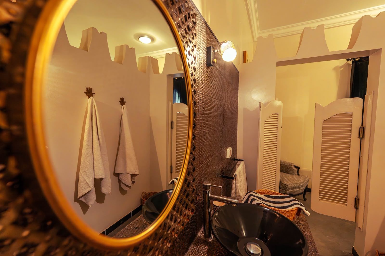 Un baño con espejo, toallas, lavabo y zona de ducha.