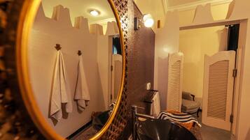 Un baño con espejo, toallas, lavabo y zona de ducha.