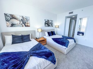 A hotel room with two beds, a nightstand with a lamp, and artwork on the walls. - Modern Pininfarina Resort Style 2BR APT w-Bay View (Hallandale Beach)