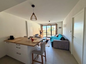 Ein kompakter Wohnbereich mit Küchenzeile, Essbereich und einer Couch.