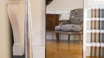 Una habitación con un espejo grande que refleja una silla y un sofá estampado.