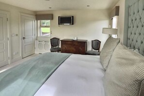 A bedroom with a bed, a dresser, a television, and two chairs. - Luxury Self-catering Home near Lahinch Golf Club - Howards Way Liscannor (Liscannor)