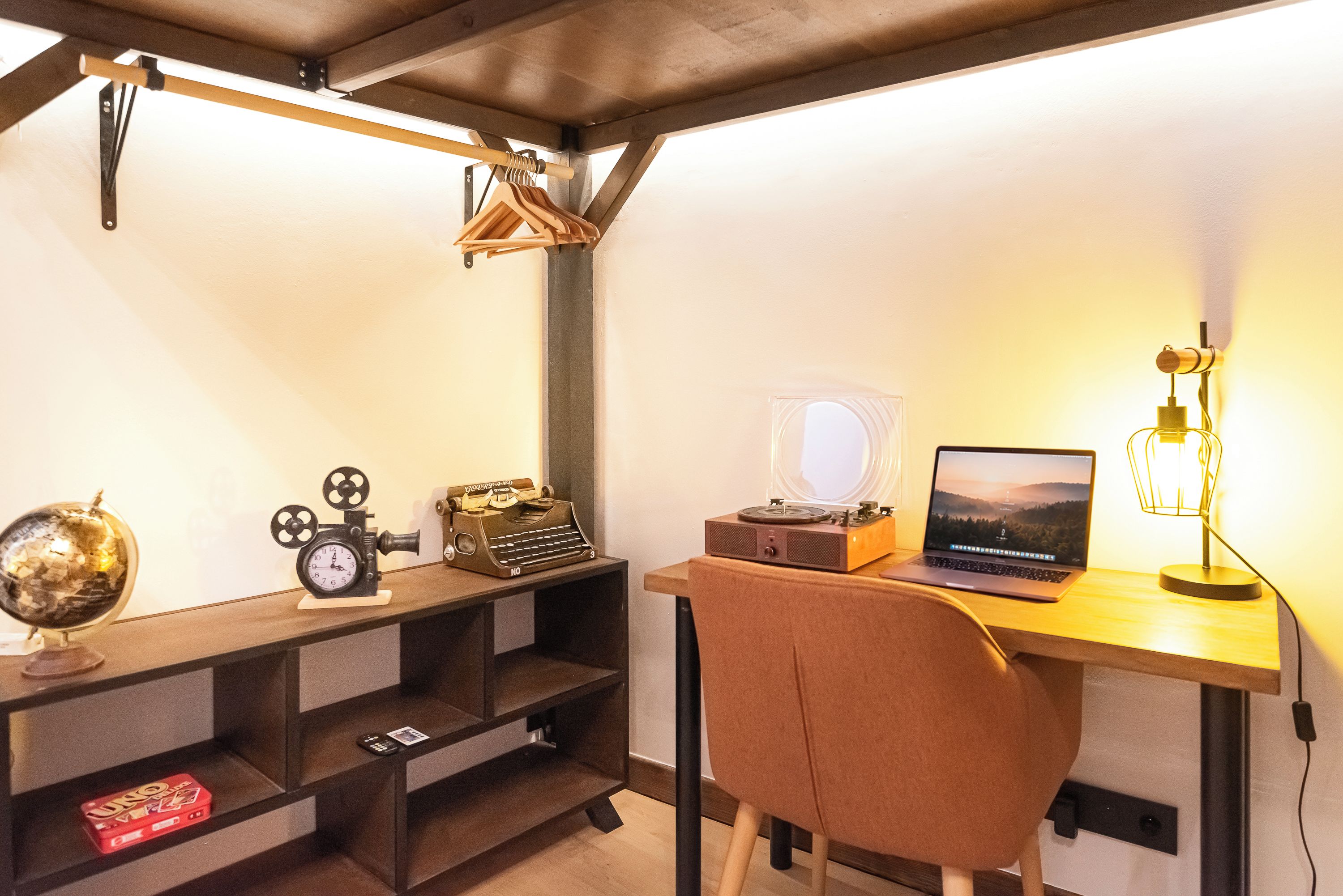 A study room with a desk, chair, shelves, and a globe.