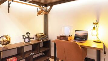 A study room with a desk, chair, shelves, and a globe.