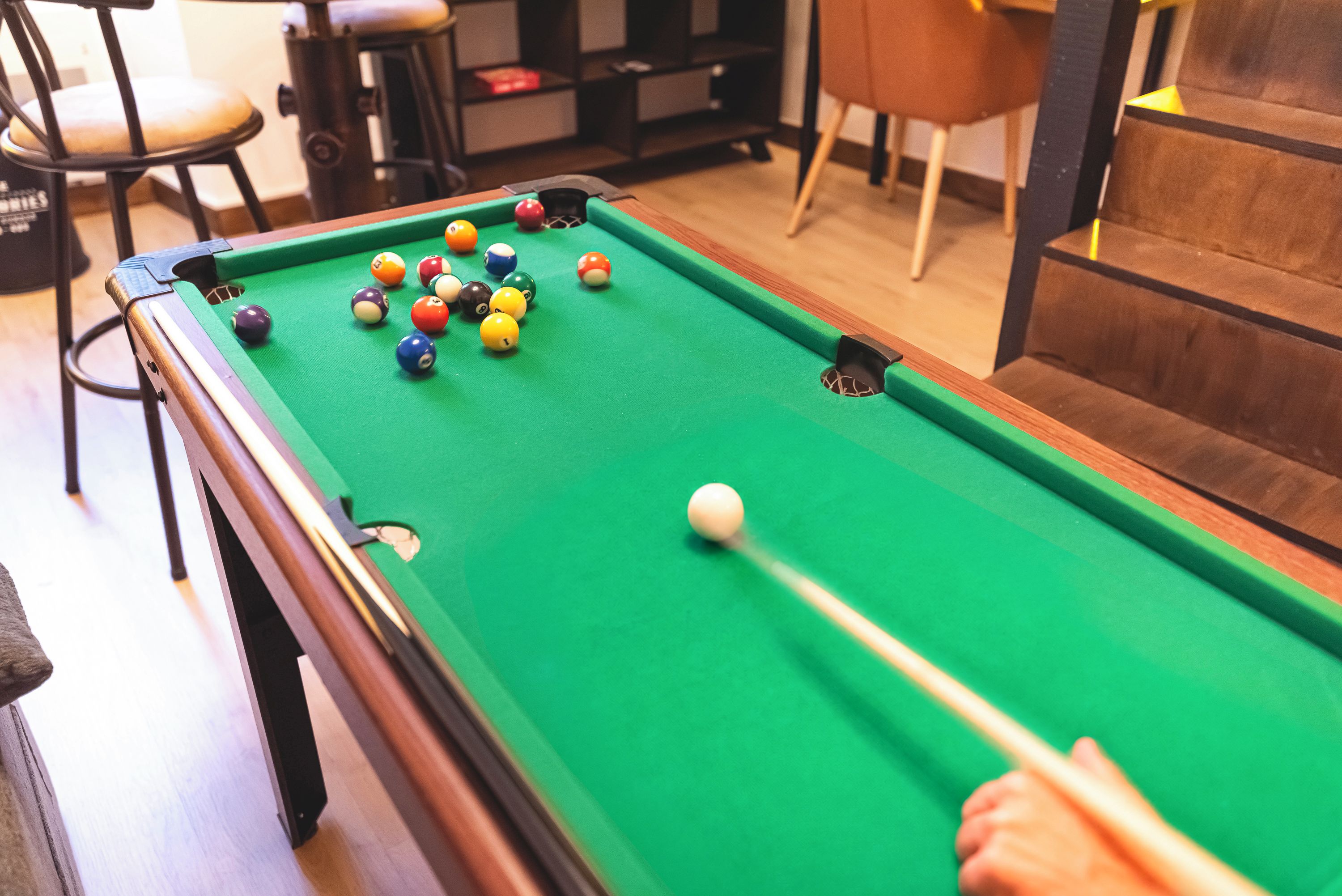 A pool table with balls in a casual indoor setting.