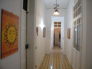 A hallway with a checkered floor, a door on the left, and a light fixture above. - Holiday Home 'Mi manda Picone da Lolli's Liberty Apartment' with Balcony and Air Conditioning (Palermo)