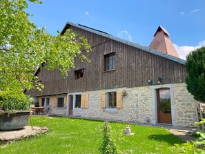 Ein rustikales, zweistöckiges Gebäude mit einer Stein-Fassade und einem Holzbalkon.