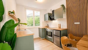 Eine moderne Küche mit Holzarbeitsplatte, eingebautem Backofen und einem Fenster für natürliches Licht.