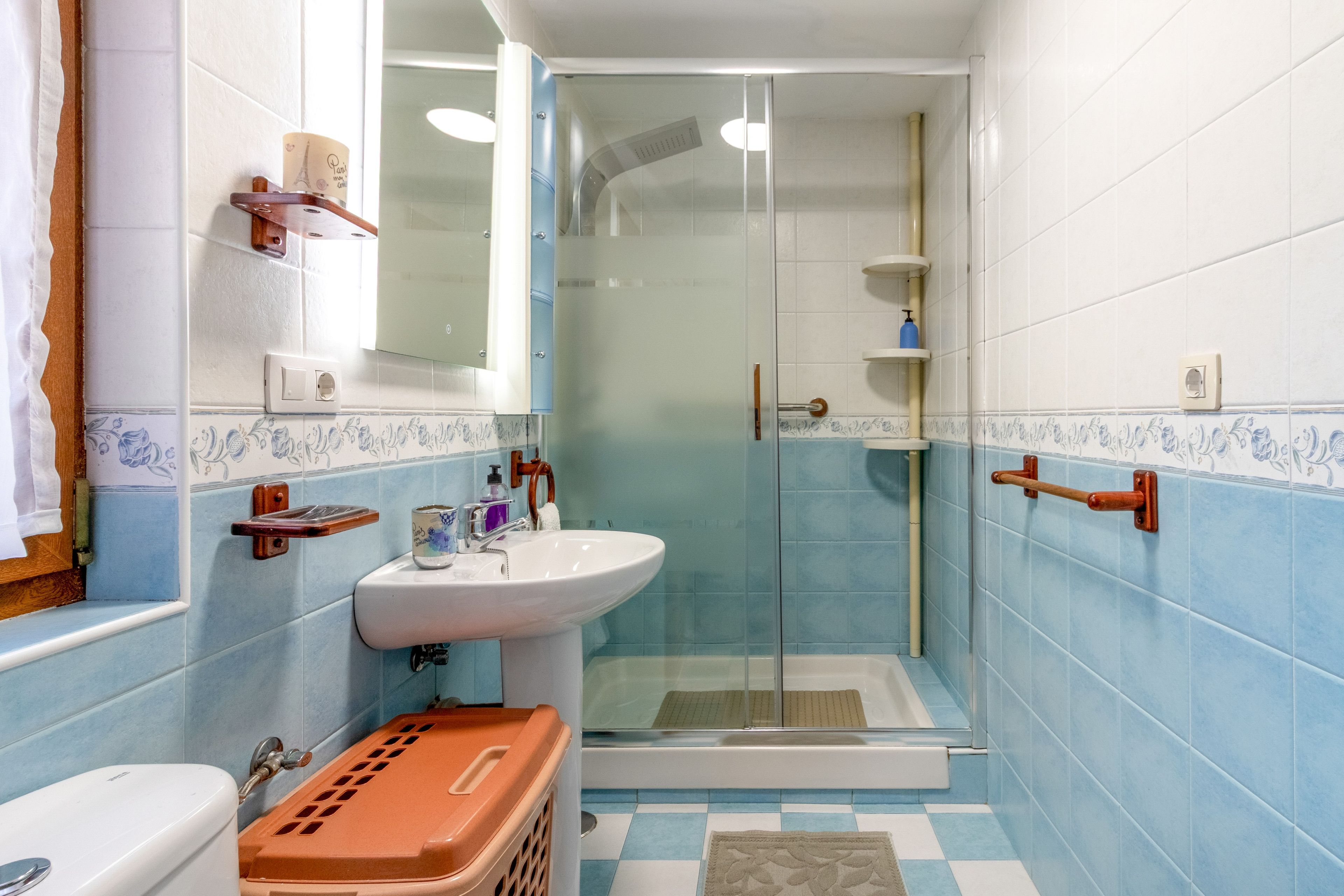 Een badkamer met een douche, wastafel en toilet.