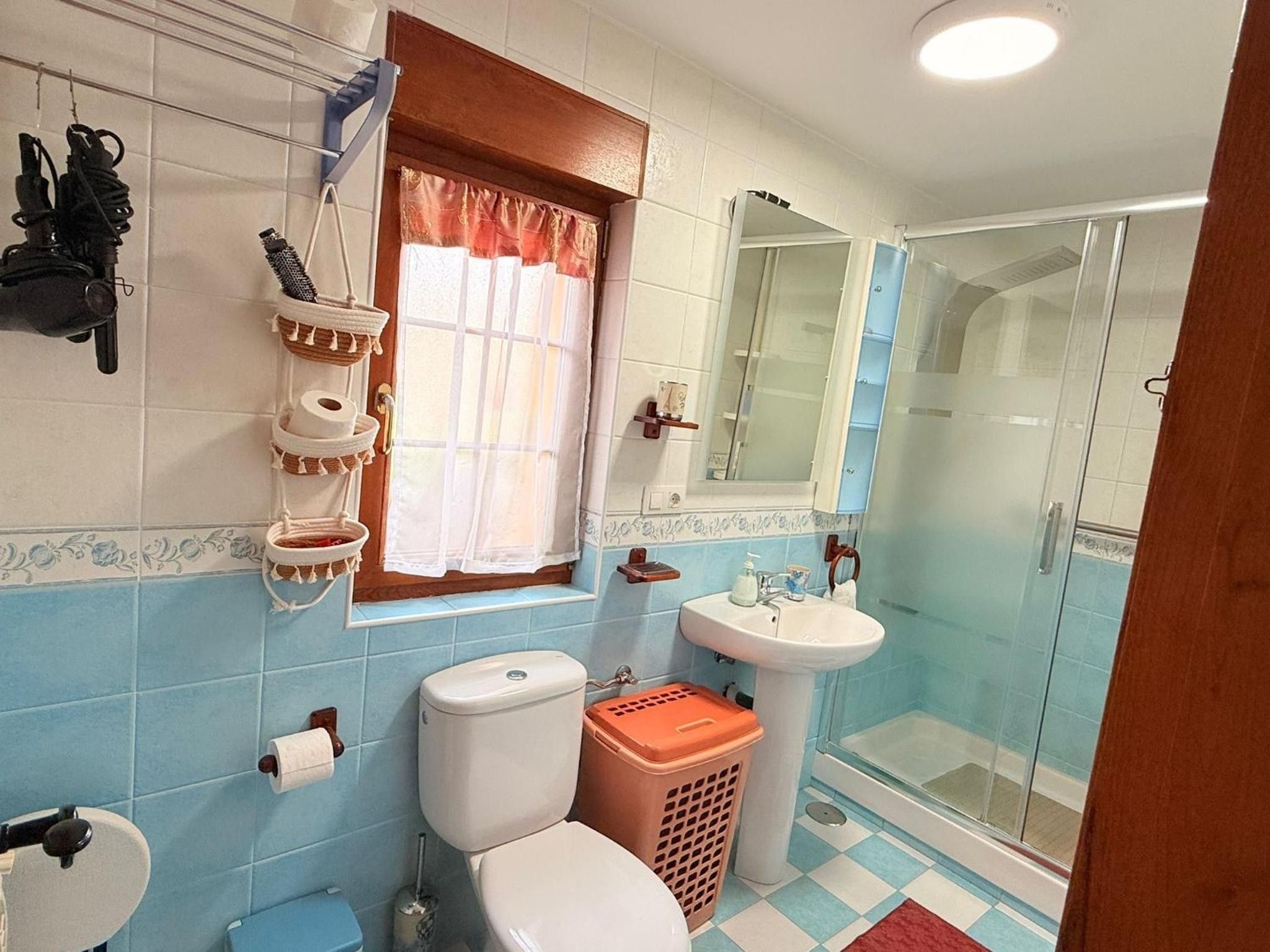Un baño con inodoro, lavabo y ducha.