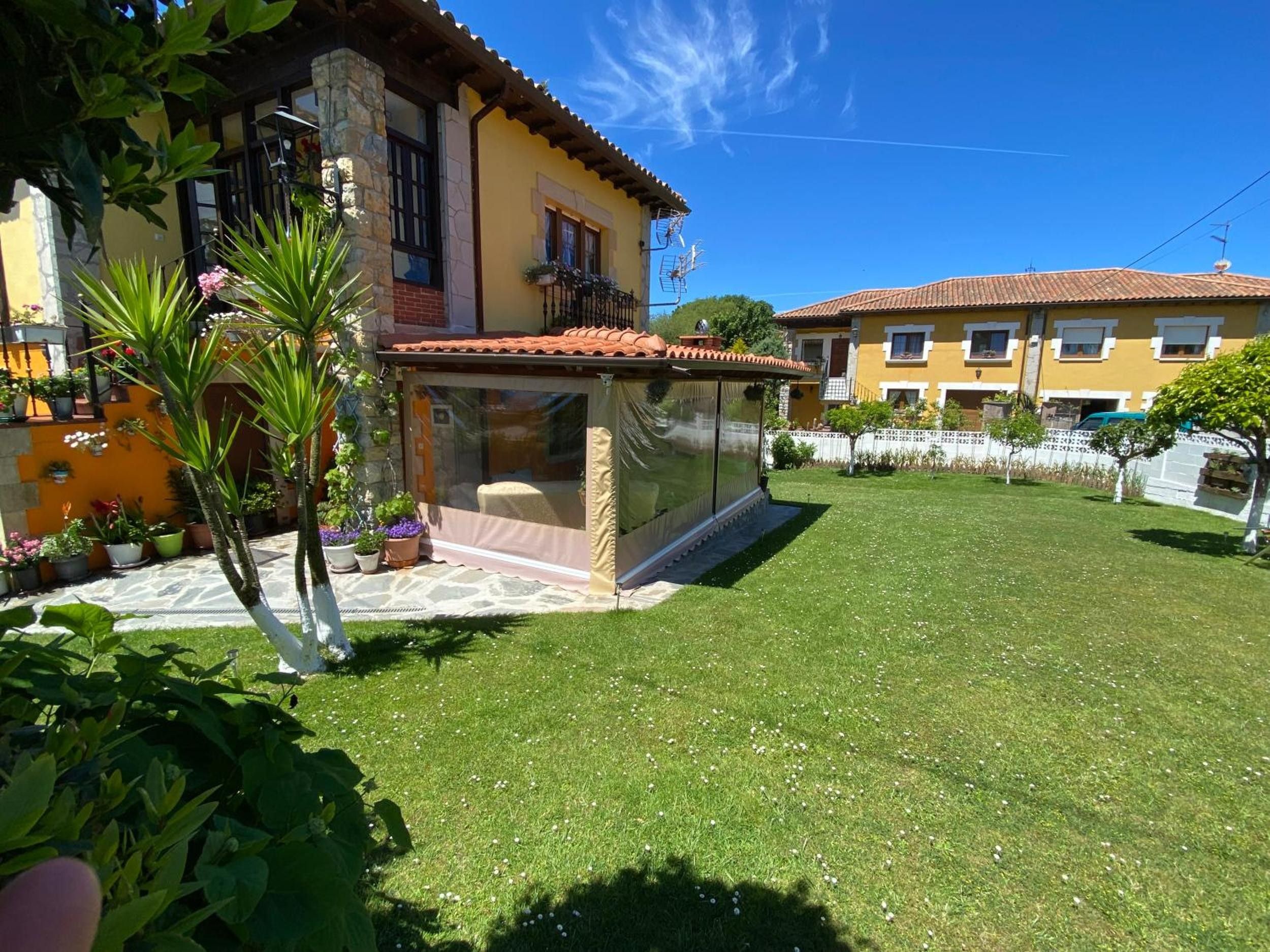 Una propiedad residencial con un patio cubierto, un césped bien cuidado y un edificio vecino.