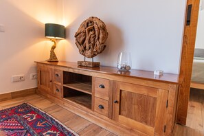 A wooden console table with a lamp, decorative piece, and glassware. - Farm Lodges Olive, Casa Alfarrobeira, Moncarapacho Countryside (moncarapacho)