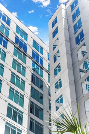 A modern building with a grid of windows and a clear sky. - The Monaco - Luxe 1BR Condo DT w/ Rooftop Pool (Orlando)