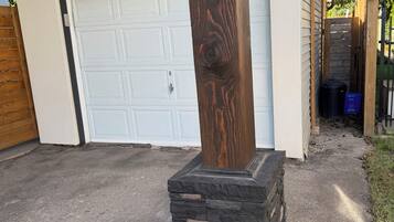 A garage door, a wooden post, and a stone base.