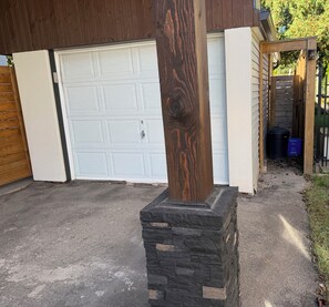 Une porte de garage, un poteau en bois et une base en pierre.