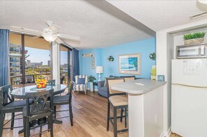 Un apartament modern amb zona de menjador, cuina i un balcó amb vista a la ciutat.
