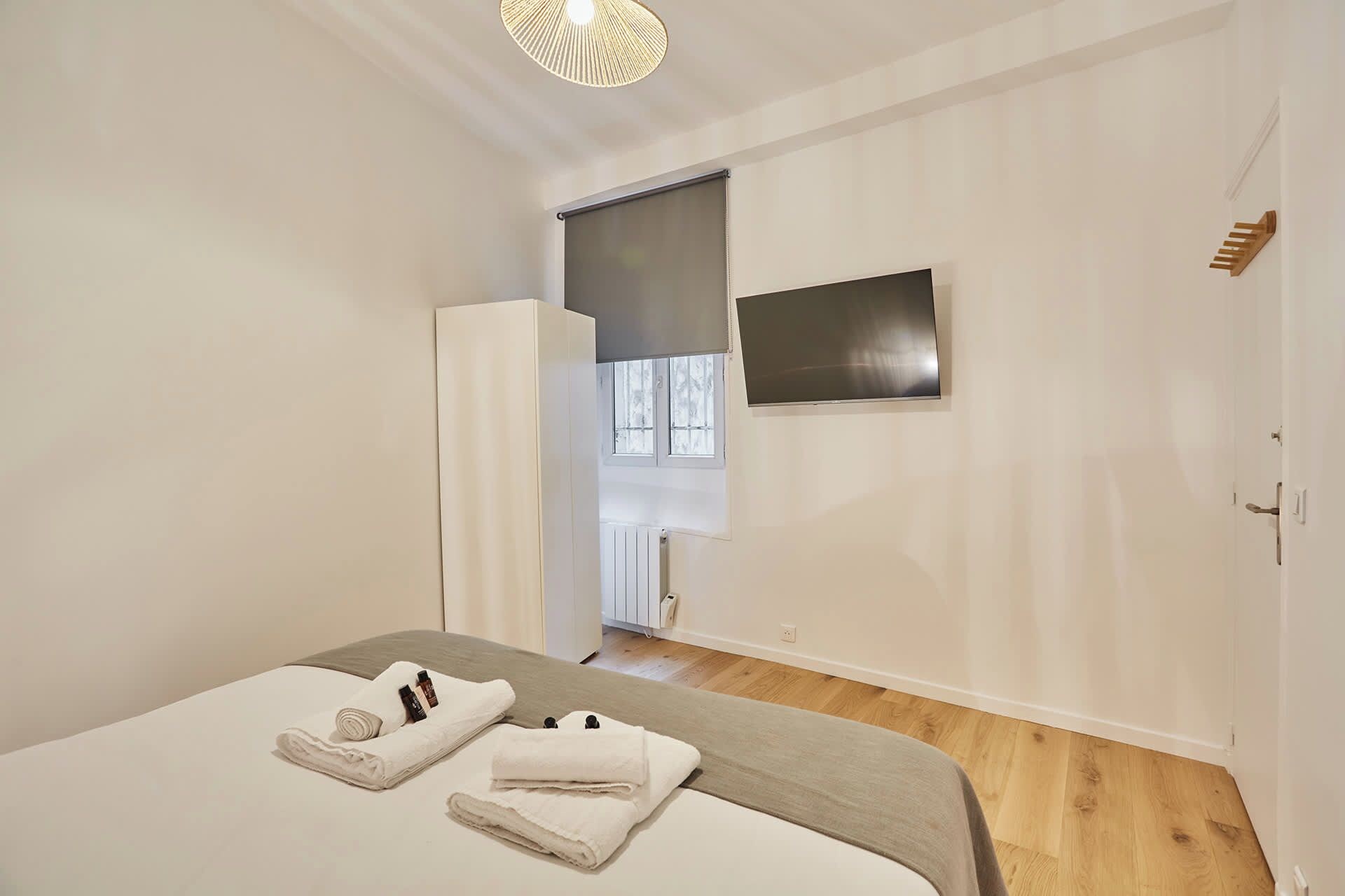Ein Schlafzimmer mit einem Bett, einem an der Wand montierten Fernseher und einem Fenster mit Blick.