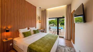 A hotel room with a bed, bedside table, lamp, and a view of a swimming pool.