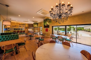 A restaurant with a bar area, seating arrangements, and a view of the outdoors.