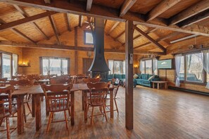 A spacious wooden interior with a high ceiling, a fireplace, and a television. - Chalet de Réception Domaine de l'Archipel (Sainte-Anne-de-Sorel)