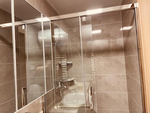 A glass-enclosed shower stall with a handheld showerhead and a wall-mounted faucet. - Cloudwards City Homestay Zhengzhou (Zhengzhou)