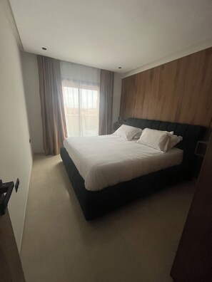 A hotel room with a bed, curtains, a window, and a wooden wall. - Marrakech, Guéliz, Dar Mekki (Marrakech)