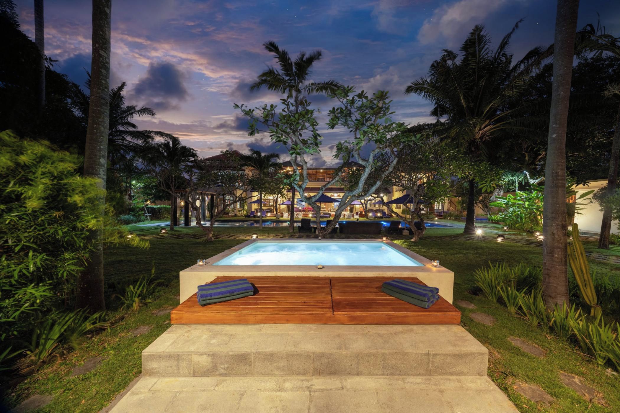 A pool area with wooden loungers and a view of a building in the background.