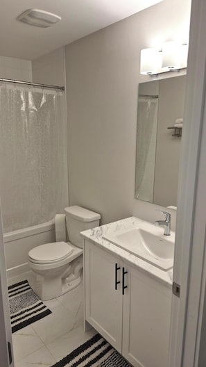 A bathroom with a toilet, sink, and shower.