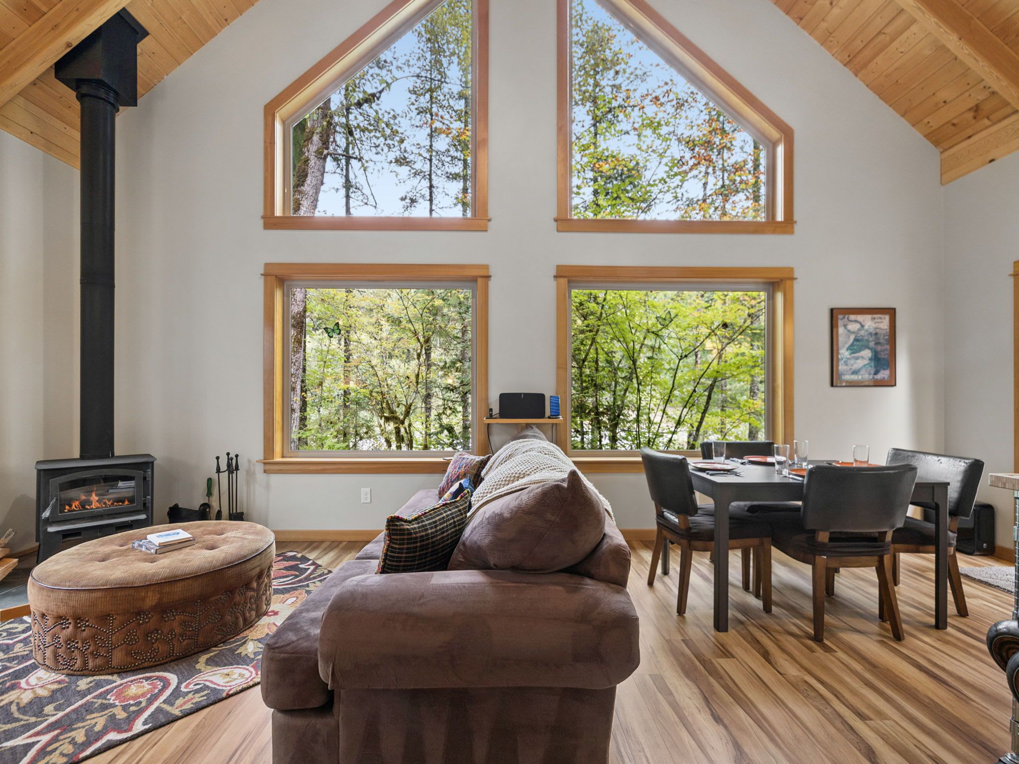 A spacious living room with a fireplace, large windows, and a cozy seating area.