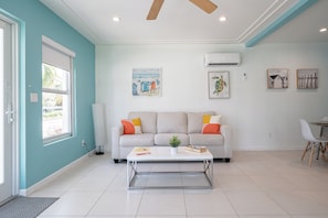 A modern living room with a sofa, coffee table, and artwork on the walls. - 1BR Apartment Steps to Hollywood Beach & Broadwalk (Hollywood)
